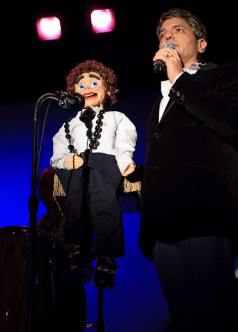 Junior Kekuewa Jr. performing live with a ventriloquist figure