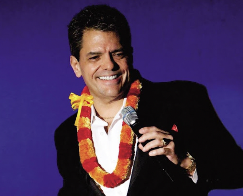 Junior Kekuewa Jr. smiling and holding a microphone